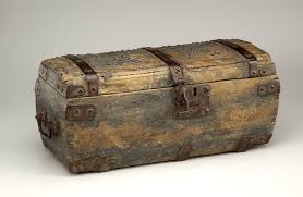 Antique wooden chest with metal straps and latch, sitting on a plain background. The weathered texture suggests age and history.