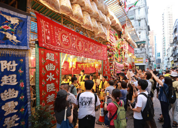 A modern Asian city with people lined up at a play