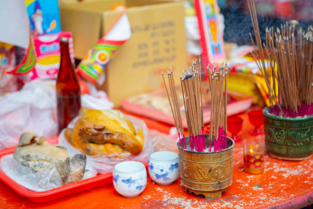 A table laden with food and containers of incense