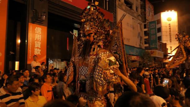 A city street at night in Asia and spectators are watching a ghost parade
