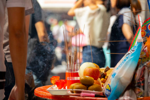 A table laden with fresh foods and sticks of burning incense