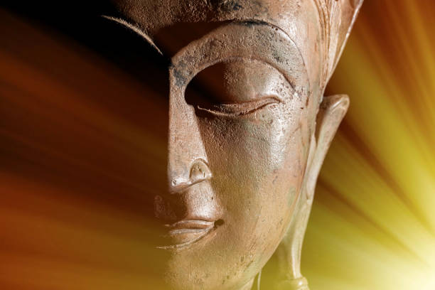A peaceful face of the buddah illuminated from behind