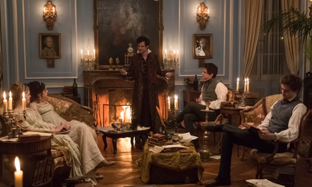 A group of people in a victorian sitting room around a fire discussing spooky things