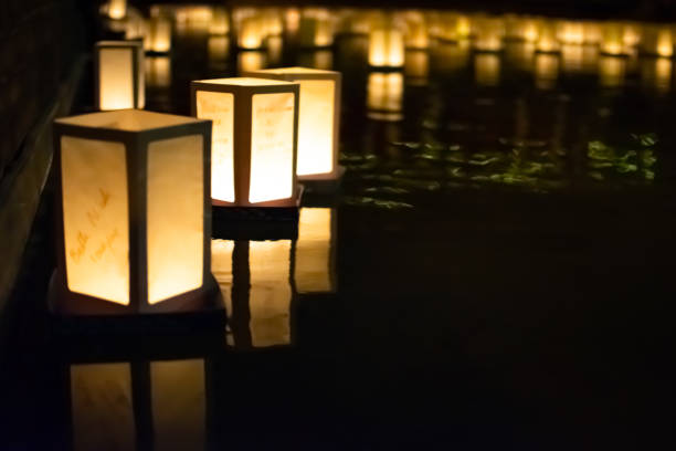 Lanterns float on a river at night