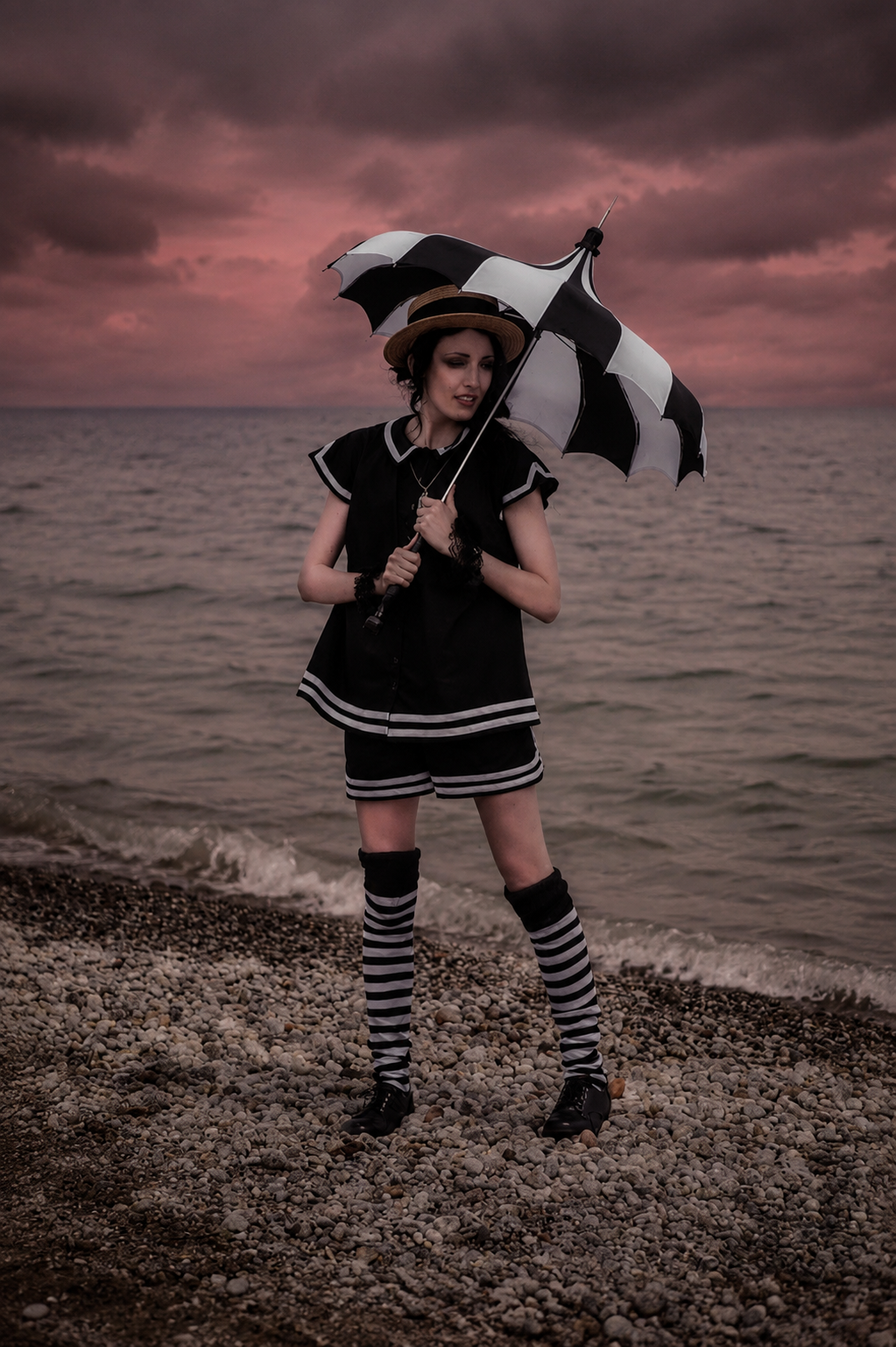 A woman in a gothic bathing suit on the beach on a cloudy day