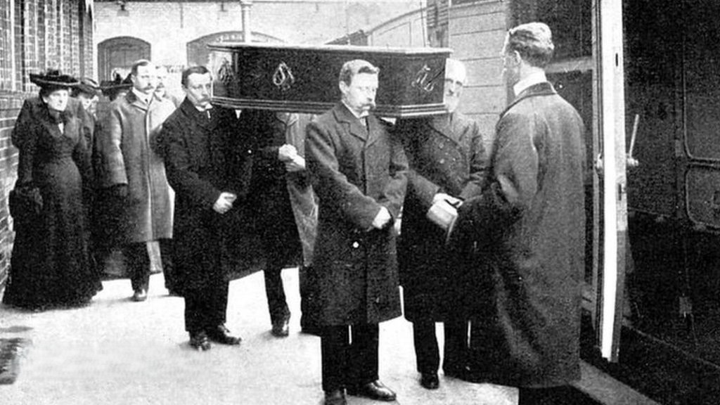 Victorian photograph of palbearers loading a coffin onto a train