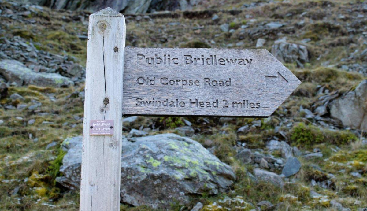 Wooden streetsign pointing toward the corpse road