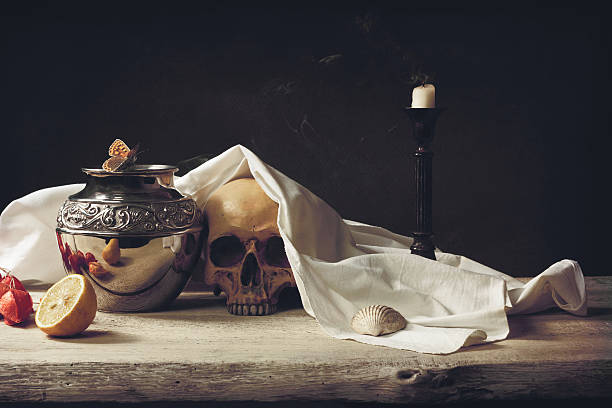 A stone table decorated with a skull, urn, fruit,candle and a shroud