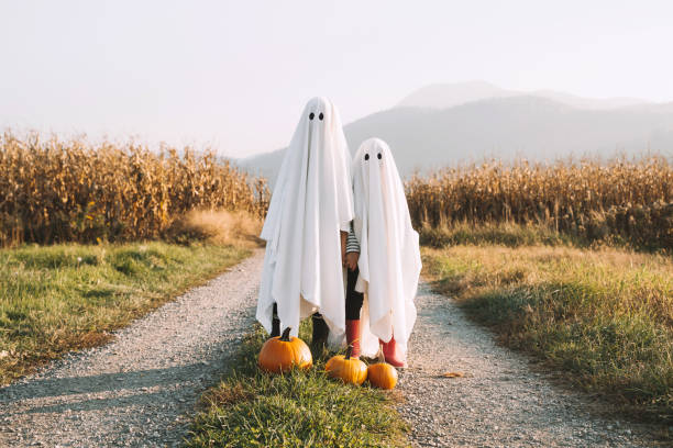 Children in a cornfiield dressed as a sheet ghost