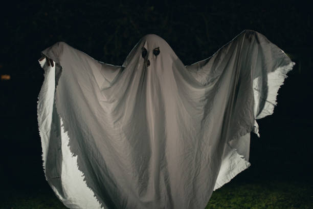 A person dressed in a sheet pretending to be a ghost